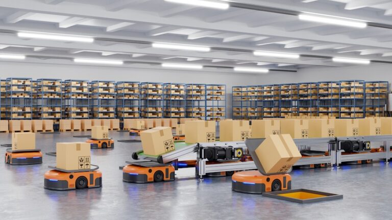 Interno di magazzino in cui sono presenti una serie di Autonomous Mobile Robots (AMR) - robot mobili autonomi - mentre sollevano e trasportano pacchi.