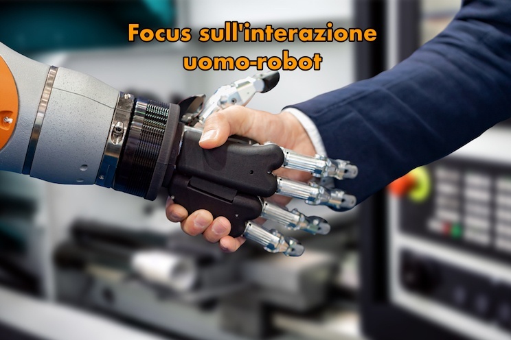Immagine con, in primo piano, la mano di un robot umanoide che stringe la mano di un essere umano, a esprimere il concetto di interazione tra uomo e robot.